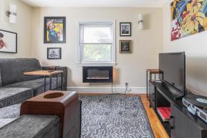 a living room with a couch and a tv at Pet-Friendly Cranston Home with Fire Pit and BBQ! in Cranston