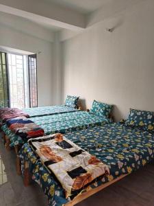 twee bedden naast elkaar in een slaapkamer bij Traveller's Nest By My Fav Nest in Siliguri
