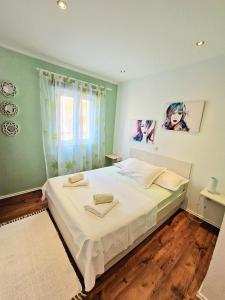 a bedroom with a large white bed with a window at DOROTEA3 in Makarska