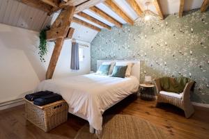 ein Schlafzimmer mit einem großen Bett und einem Stuhl in der Unterkunft Le Moulin Saint-Nicolas 