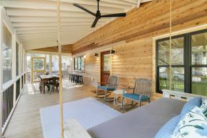 a wooden house with a porch with a swing at 1st Block E Hudson - Green Wave - Newly Remodeled - Pool and Hot Tub - Ideal Central Location in Folly Beach