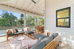 a screened in porch with couches and a table at 1st Block E Hudson - Green Wave - Newly Remodeled - Pool and Hot Tub - Ideal Central Location in Folly Beach