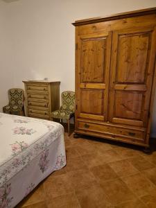 een slaapkamer met een bed en een houten kast bij Agriturismo Campo Contile in Chianciano Terme