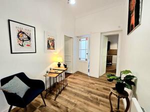 a living room with a black chair and a table at Le victor hugo - coeur de ville in Nîmes