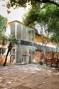 a glass building with a bench in front of it at Carlton Plaza Baobá in Taubaté