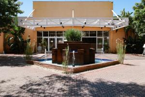 a building with a fountain in front of it at Carlton Plaza Baobá in Taubaté