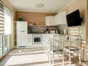 グラール・ミューリッツにあるfewo-ostsee24の白いキャビネット、テーブルと椅子付きのキッチンが備わります。