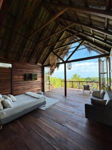 1 dormitorio con 1 cama en una terraza de madera en Cabaña Vista al Mar Tayrona, A/C, en Los Naranjos