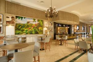 a restaurant with tables and chairs and a large painting on the wall at Bahia Principe Grand Jamaica - All Inclusive in Runaway Bay