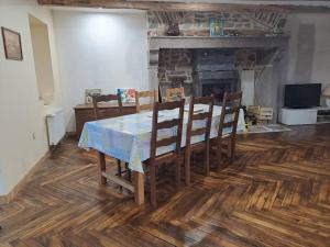 une salle à manger avec une table, des chaises et une cheminée dans l'établissement Ferme auvergnate, à Tauves