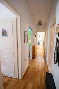 ein Flur mit einer weißen Tür und einem Holzboden in der Unterkunft Dreamy relaxing secluded Villa Aurora in Palaia Fokaia