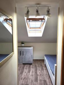 an attic room with a skylight and a room with a bed at Guesthouse Ožegović in Belgrade