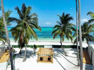 a beach with palm trees and the ocean at The Zanzibar Beach House-South in Pingwe