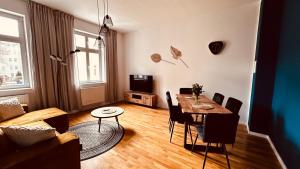 a living room with a table and chairs and a couch at Apartment NATUR in Halle an der Saale in Halle an der Saale