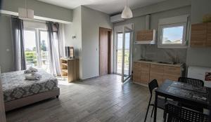 a bedroom with a bed and a kitchen with a table at Nikitas Apartments & Suites in Kanali