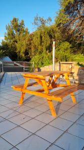 einem Picknicktisch aus Holz auf einer Terrasse in der Unterkunft Altos de Capilla in Capilla del Monte