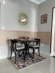a dining room table with two chairs and a mirror at Santos Linda!! Apartment for Business and Leisure. in Santos
