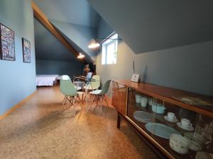 a living room with a glass cabinet with a table and chairs at Guest house Eça Agora! in Vila do Conde