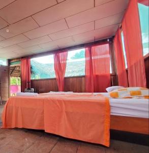 een slaapkamer met 2 bedden en een groot raam bij Bromelia Flower Lodge Iquitos in Iquitos