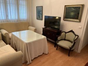 - un salon avec une table et une télévision dans l'établissement 2 Bedroom Apartment by Guadalquivir River, à Séville