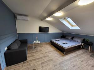 a room with a bed and a couch and a tv at Guesthouse Ožegović in Belgrade