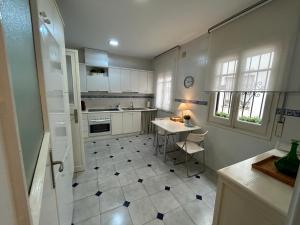 une cuisine avec des placards blancs et une table. dans l'établissement 2 Bedroom Apartment by Guadalquivir River, à Séville