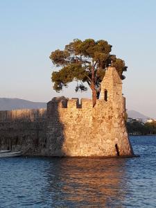 um castelo na água com uma árvore sobre ele em ART HOUSE NAFPAKTOS em Káto Platanítis