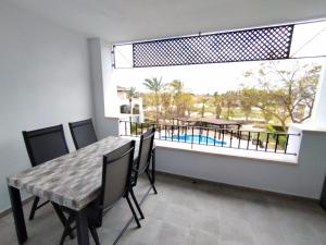 une salle à manger avec une table et une grande fenêtre dans l'établissement Apartamento La Torre Golf, à Torre-Pacheco