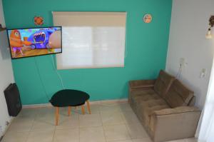 ein Wohnzimmer mit einem Sofa und einem Flachbild-TV in der Unterkunft Refugio del alma. Alquiler temporario. in Zavalla