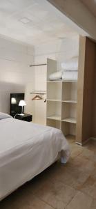 een slaapkamer met een wit bed en planken bij Departamento Divino a tres cuadras de la playa. in Carilo