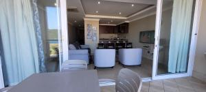 eine Küche und ein Esszimmer mit weißen Stühlen und einem Tisch in der Unterkunft Accommodation Front - Relaxing 2 Sleeper near Ushaka Marine World in Durban