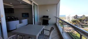 einen Balkon mit einem Tisch und Strandblick in der Unterkunft Accommodation Front - Relaxing 2 Sleeper near Ushaka Marine World in Durban