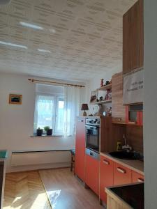uma cozinha com um frigorífico vermelho e uma janela em River View Apartment Gospic em Gospić