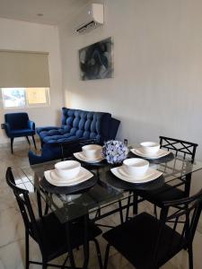 een eetkamer met een tafel met stoelen en een blauwe bank bij Departamento Puerta Dorada in Manzanillo