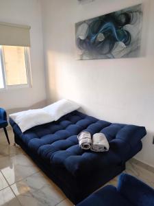 een grote blauwe bank in een kamer met een schilderij bij Departamento Puerta Dorada in Manzanillo