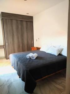een slaapkamer met een groot bed en handdoeken bij Departamento Puerta Dorada in Manzanillo