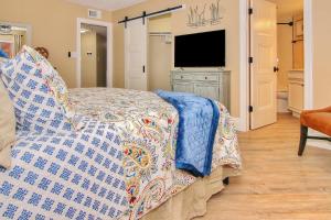 a bedroom with a bed and a flat screen tv at Reef Club 307 in Clearwater Beach