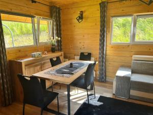 ein Esszimmer mit einem Tisch und Stühlen in einer Hütte in der Unterkunft Wzgórze w Cieniu Lasu in Łukowica