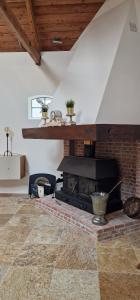 a living room with a brick fireplace in a room with a ceiling at Huize Dijkwater in Dreischor