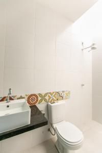 a white bathroom with a sink and a toilet at CASA ORGANIC in Caucaia