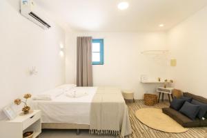 a white bedroom with a bed and a chair at CASA ORGANIC in Caucaia