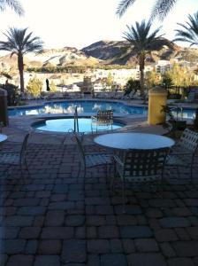 a table and chairs next to a pool with palm trees at Lake Las Vegas Resort Vacation in Las Vegas