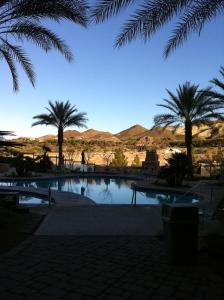 a swimming pool with palm trees and mountains in the background at Lake Las Vegas Resort Vacation in Las Vegas