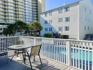 a patio with a table and chairs next to a pool at Coco Loco in Myrtle Beach