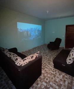 Casa de praia Amarópolis في باريبويرا: غرفة معيشة مع أريكة وتلفزيون بشاشة مسطحة
