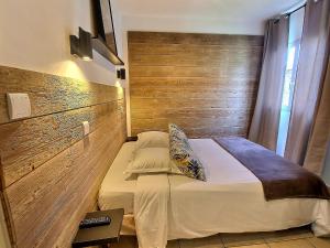 a bedroom with a bed with a wooden wall at Atlantis Hôtel in Mimizan