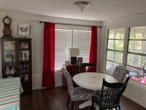 a dining room with a table and chairs and red curtains at Chic 3BR Home w/ Big Yard in Winter Park-Orlando in Orlando
