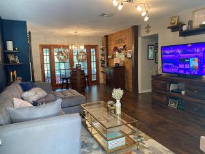 a living room with a couch and a flat screen tv at Chic 3BR Home w/ Big Yard in Winter Park-Orlando in Orlando