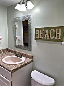 a bathroom with a toilet and a sink and a mirror at The Ocean Pearl in Myrtle Beach
