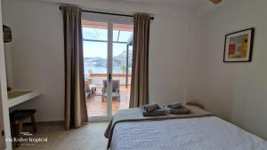 a bedroom with a bed and a sliding glass door at Los Cipreses - Casa Adán in Almuñécar